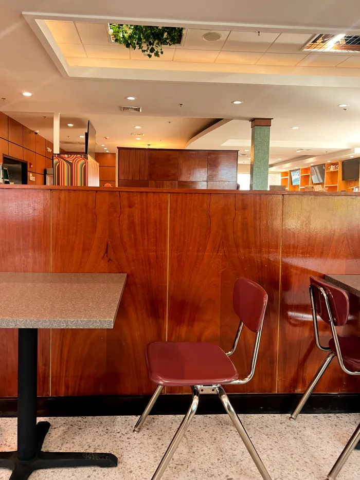 Dining room with wood paneling and red chairs
