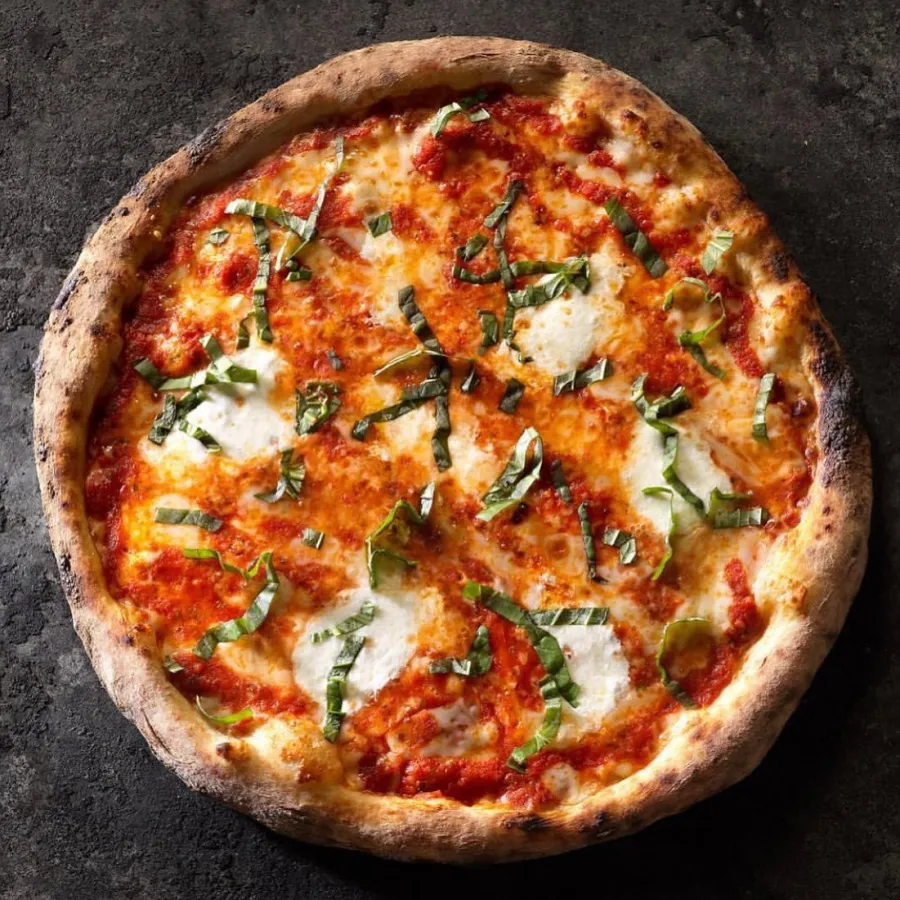Margherita pizza with fresh basil, blistered wood-fired crust